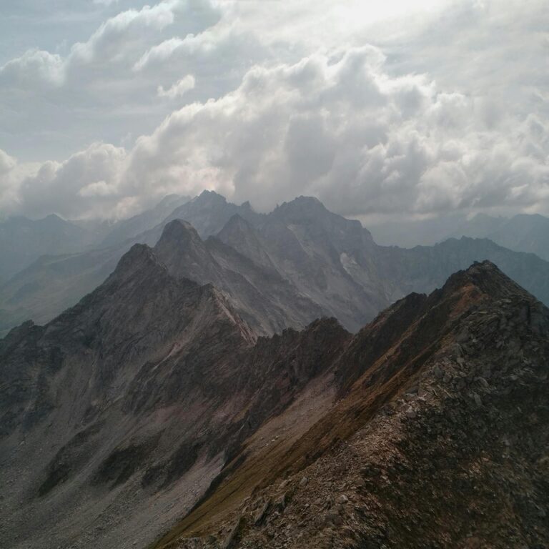 Captivating view of rugged mountain peaks surrounded by clouds, creating a dramatic landscape.