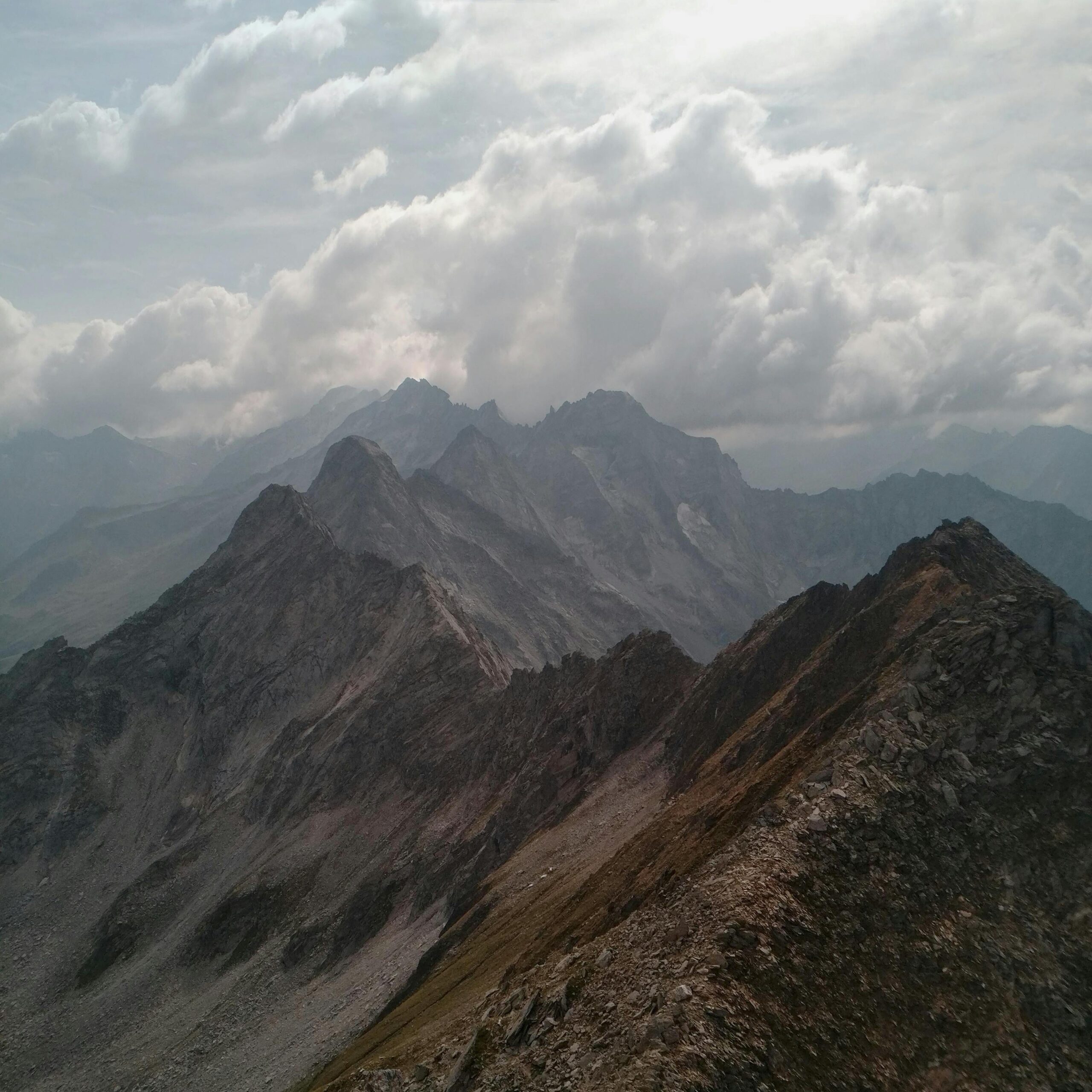 Captivating view of rugged mountain peaks surrounded by clouds, creating a dramatic landscape.